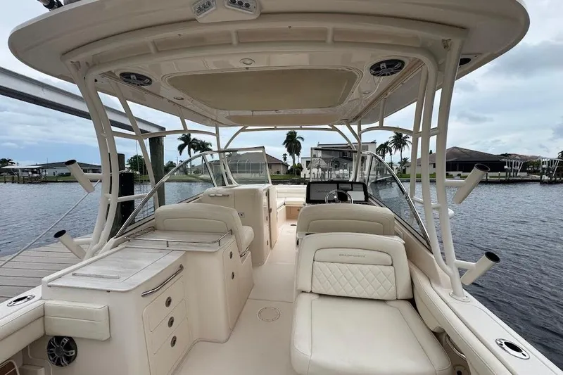  Yacht Photos Pics 2020 Grady-White Freedom 285 boat interior with seating and helm, docked by waterfront homes.