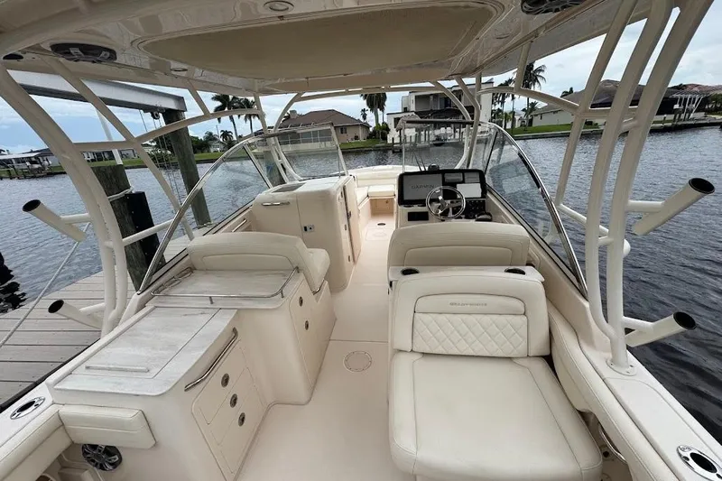  Yacht Photos Pics 2020 Grady-White Freedom 285 boat interior with luxurious seating and helm, docked by the water.