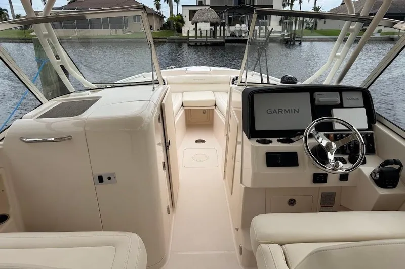  Yacht Photos Pics 2020 Grady-White Freedom 285 boat interior with Garmin navigation system, docked by waterfront homes.