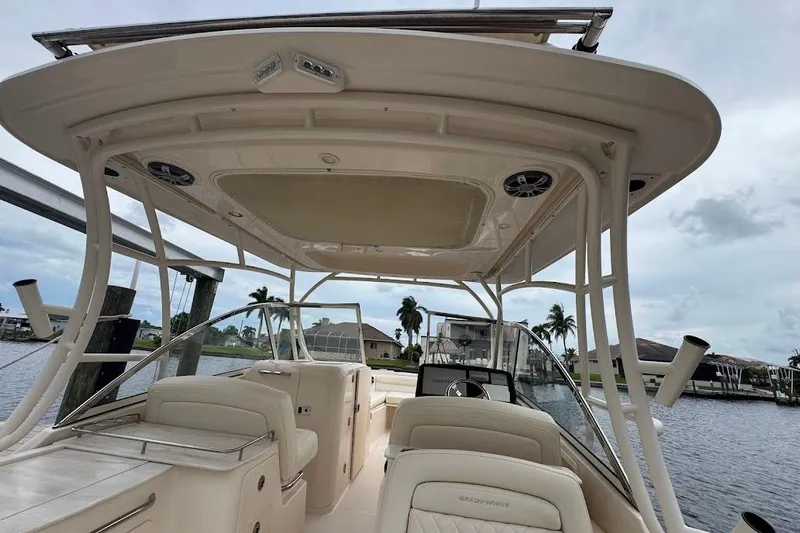  Yacht Photos Pics 2020 Grady-White Freedom 285 boat interior with seating and canopy, docked by waterfront homes.