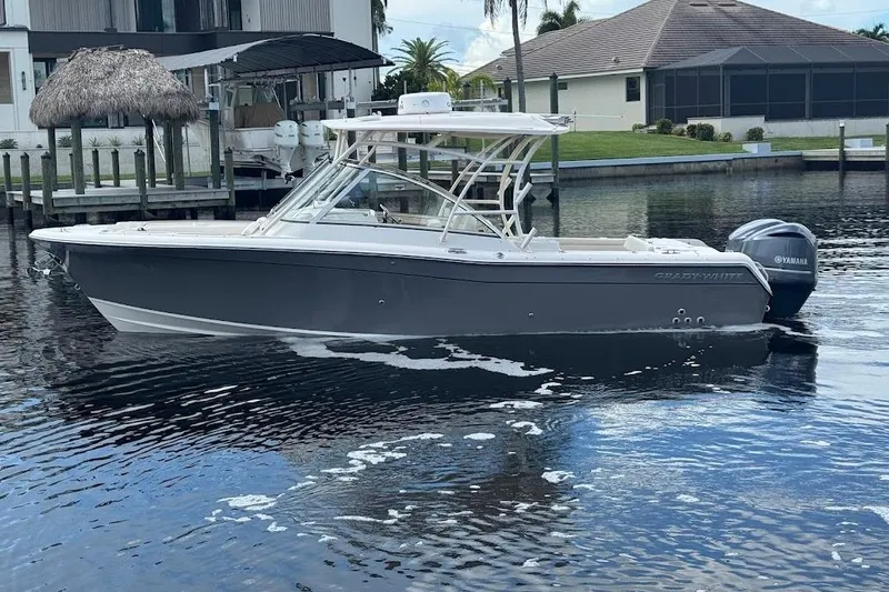  Yacht Photos Pics 2020 Grady-White Freedom 285 boat on calm water near a dock.