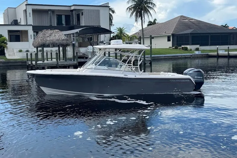  Yacht Photos Pics 2020 Grady-White Freedom 285 boat on calm water near modern waterfront homes.
