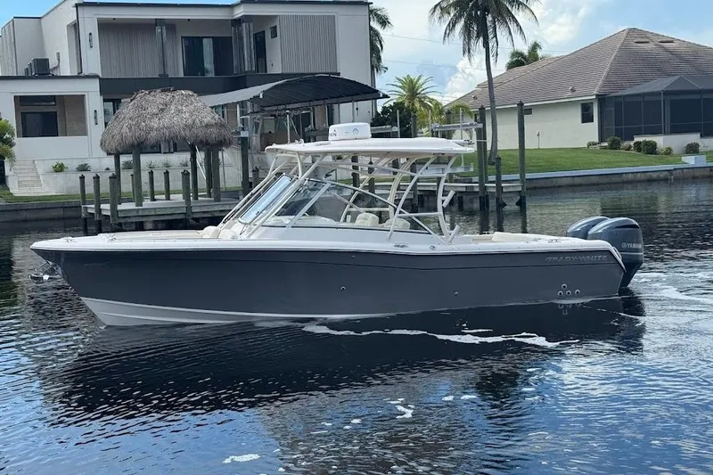  Yacht Photos Pics 2020 Grady-White Freedom 285 boat on calm water near modern waterfront homes.