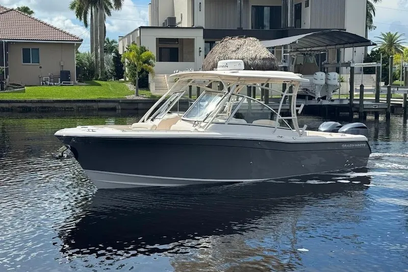  Yacht Photos Pics 2020 Grady-White Freedom 285 boat on calm water near waterfront homes.