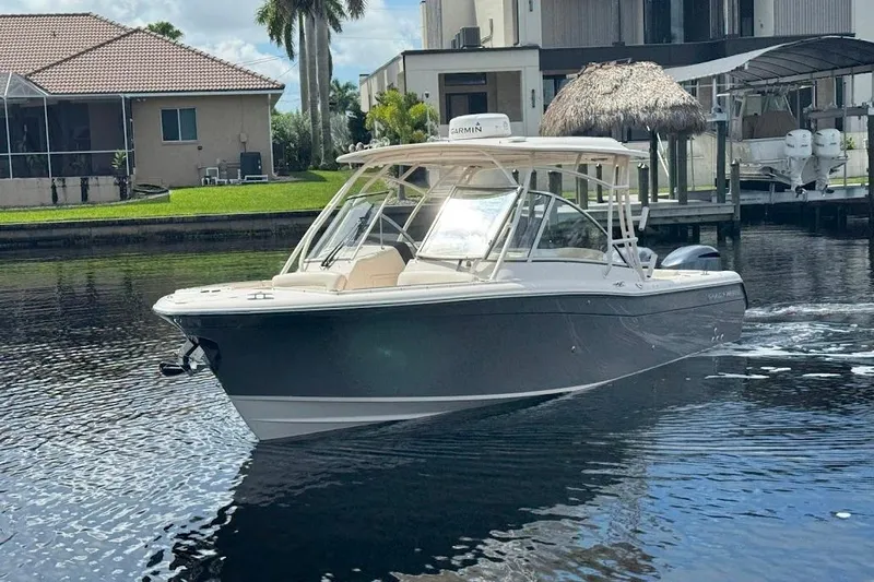  Yacht Photos Pics 2020 Grady-White Freedom 285 boat cruising on a calm waterfront near residential homes.