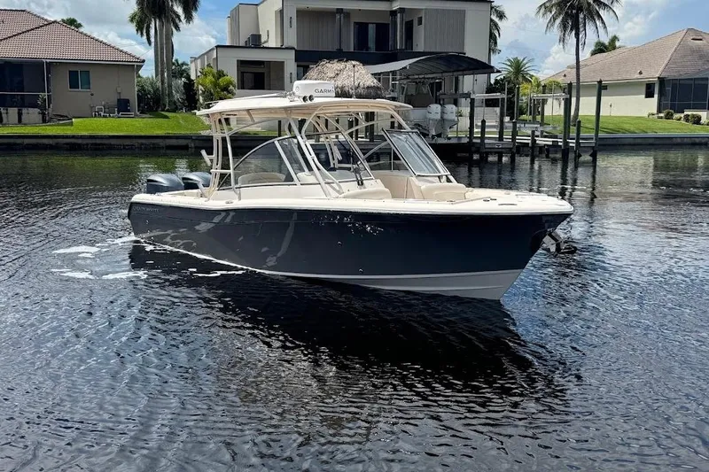 Yacht Photos Pics 2020 Grady-White Freedom 285 boat on calm water near waterfront homes.