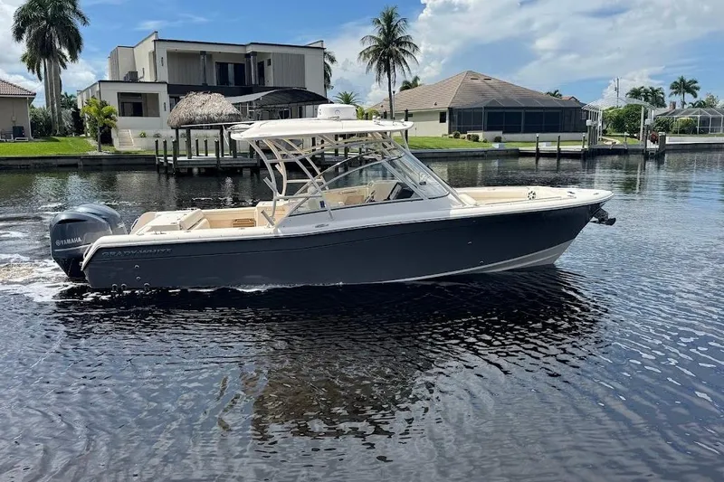  Yacht Photos Pics 2020 Grady-White Freedom 285 boat on a calm waterfront, modern homes in the background.