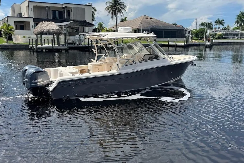  Yacht Photos Pics 2020 Grady-White Freedom 285 boat on water, near waterfront homes and palm trees.