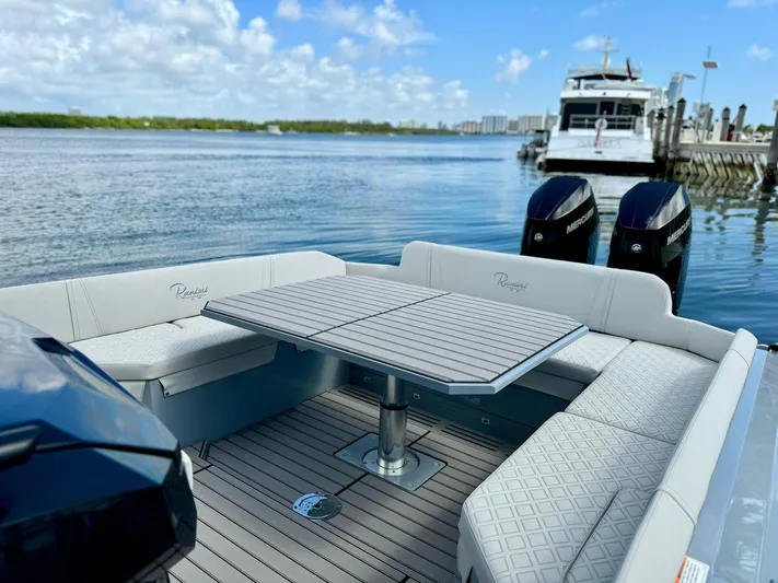  Yacht Photos Pics 2025 Ranieri CAYMAN 38.0 EXECUTIVE luxury boat with seating and table, docked by the water.
