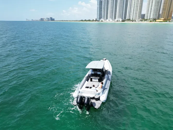  Yacht Photos Pics 2025 Ranieri CAYMAN 38.0 EXECUTIVE boat cruising near a coastal city skyline.