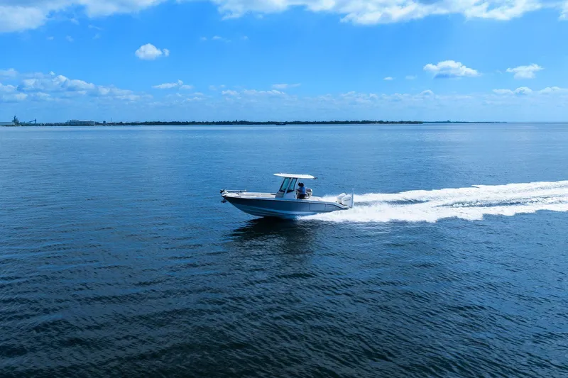  Yacht Photos Pics 2025 Boston Whaler 280 Dauntless cruising on open water under a clear blue sky.