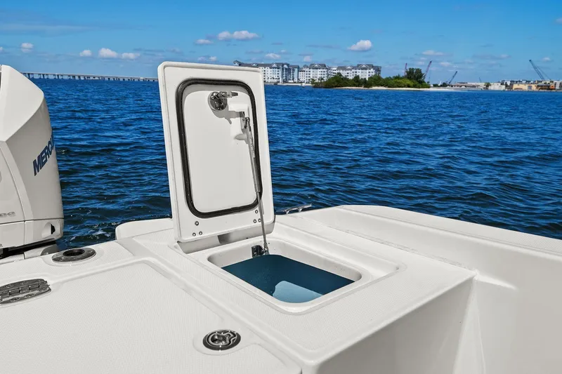  Yacht Photos Pics 2025 Boston Whaler 280 Dauntless boat with open storage compartment on calm water.