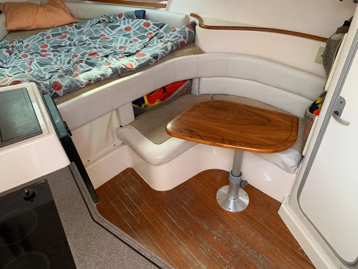  Yacht Photos Pics Interior of 2001 Grady-White 330 Express boat with cozy seating and wooden table.