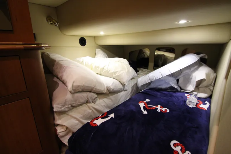  Yacht Photos Pics Cozy cabin interior of 2003 Cruisers Yachts 4450 Express Motoryacht with nautical-themed bedding.