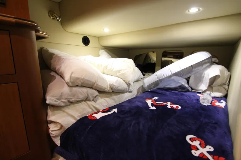  Yacht Photos Pics Cozy cabin interior of 2003 Cruisers Yachts 4450 Express Motoryacht with nautical-themed bedding.