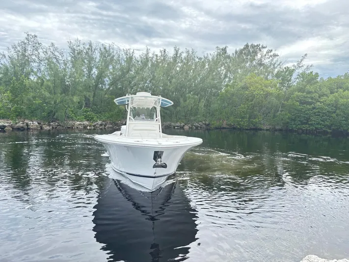  Yacht Photos Pics 2015 Regulator 34 CC boat navigating calm waters with lush greenery in the background.