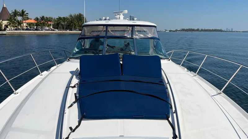 Lowest Price In Usa Yacht Photos Pics 2008 Sea Ray 44 Sundancer yacht with blue sun loungers on deck, docked by the shore.