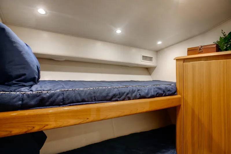 Dorothy Marie Yacht Photos Pics Cozy cabin interior of 2017 Viking 48 Convertible yacht with bunk bed and wooden cabinetry.