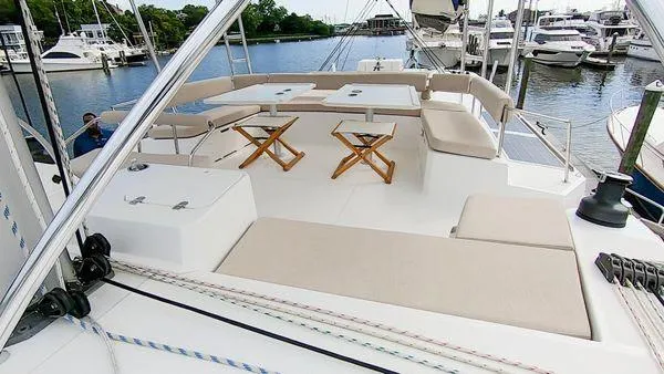 Joy Yacht Photos Pics Spacious deck of 2021 Bali 5.4 catamaran with seating and tables, docked at marina.