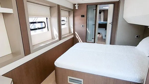 Joy Yacht Photos Pics Modern bedroom interior on a 2021 Bali 5.4 yacht, featuring large windows and a comfortable bed.