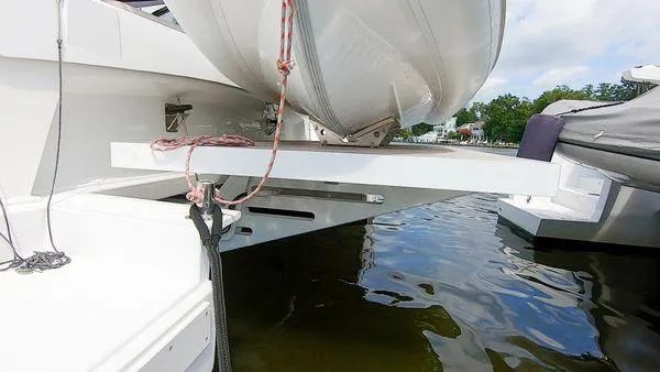 Joy Yacht Photos Pics Bali 5.4 catamaran stern view with dinghy, docked on calm water, 2021 model.
