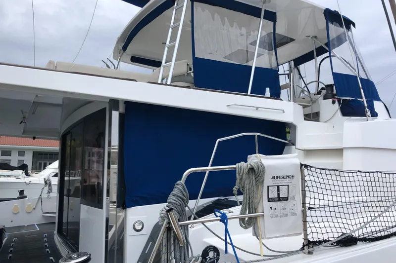 Joy Yacht Photos Pics 2021 Bali 5.4 yacht with blue canopy, docked at marina.