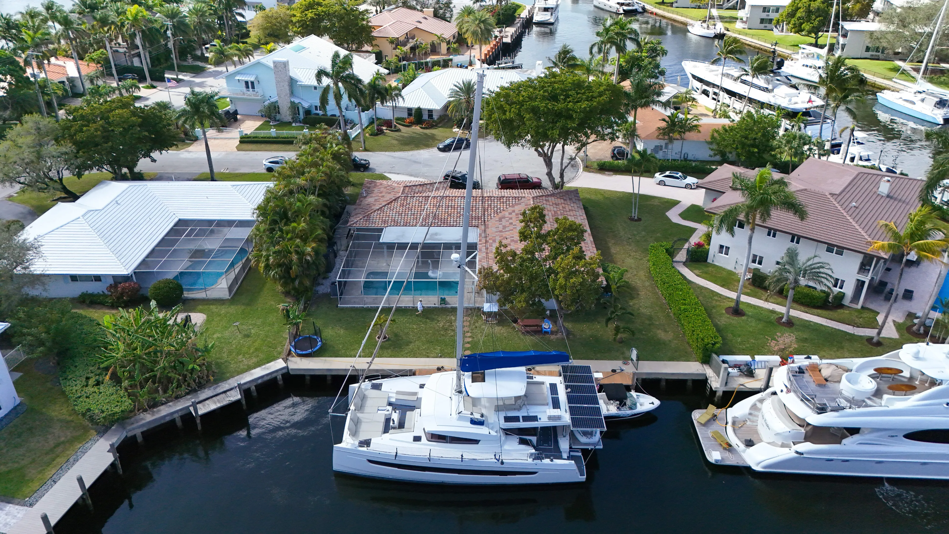 Joy Yacht Photos Pics Aerial view of a 2021 Bali 5.4 catamaran docked in a residential canal.