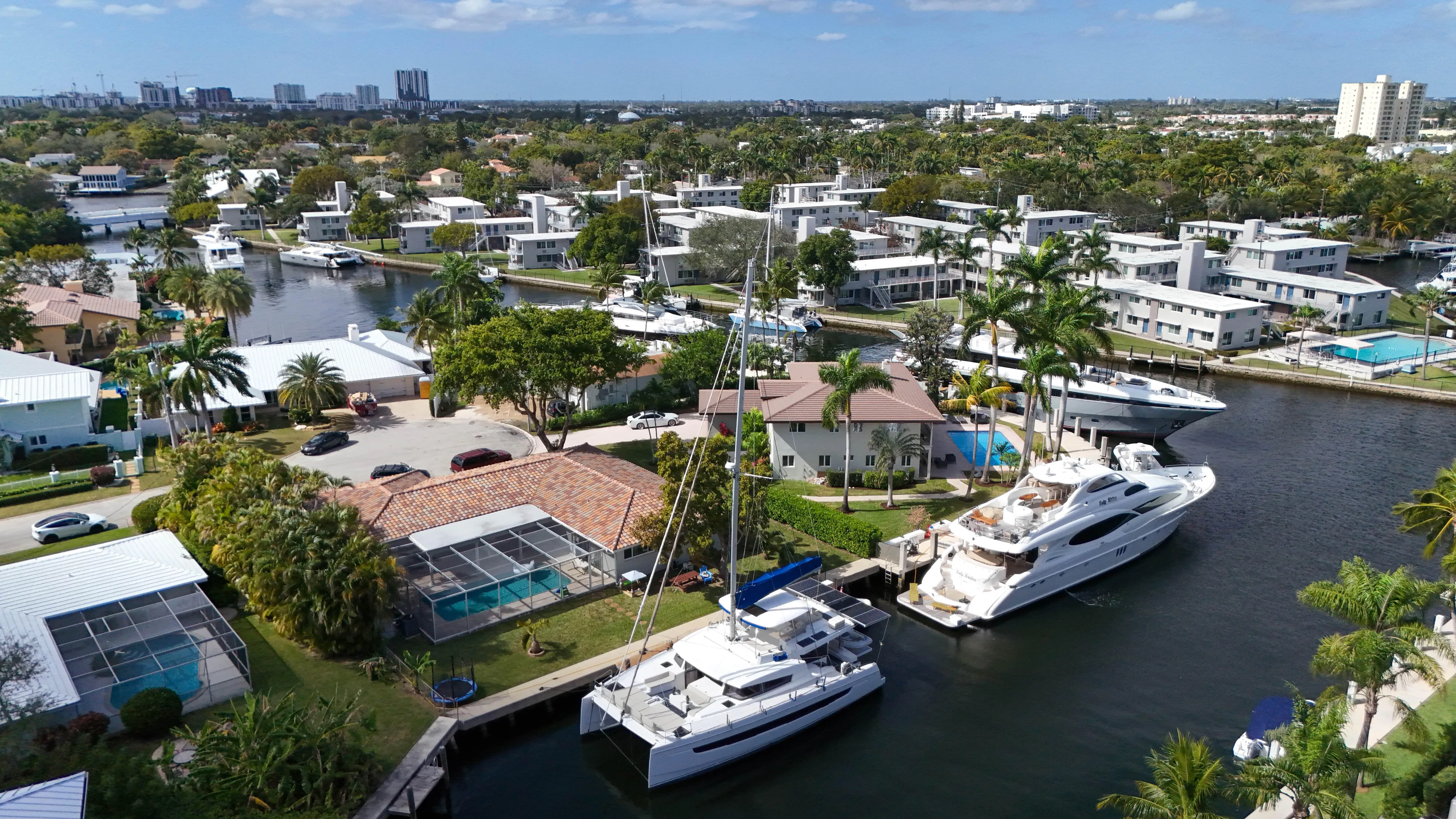 Joy Yacht Photos Pics Aerial view of luxury yachts and waterfront homes in a tropical residential area.