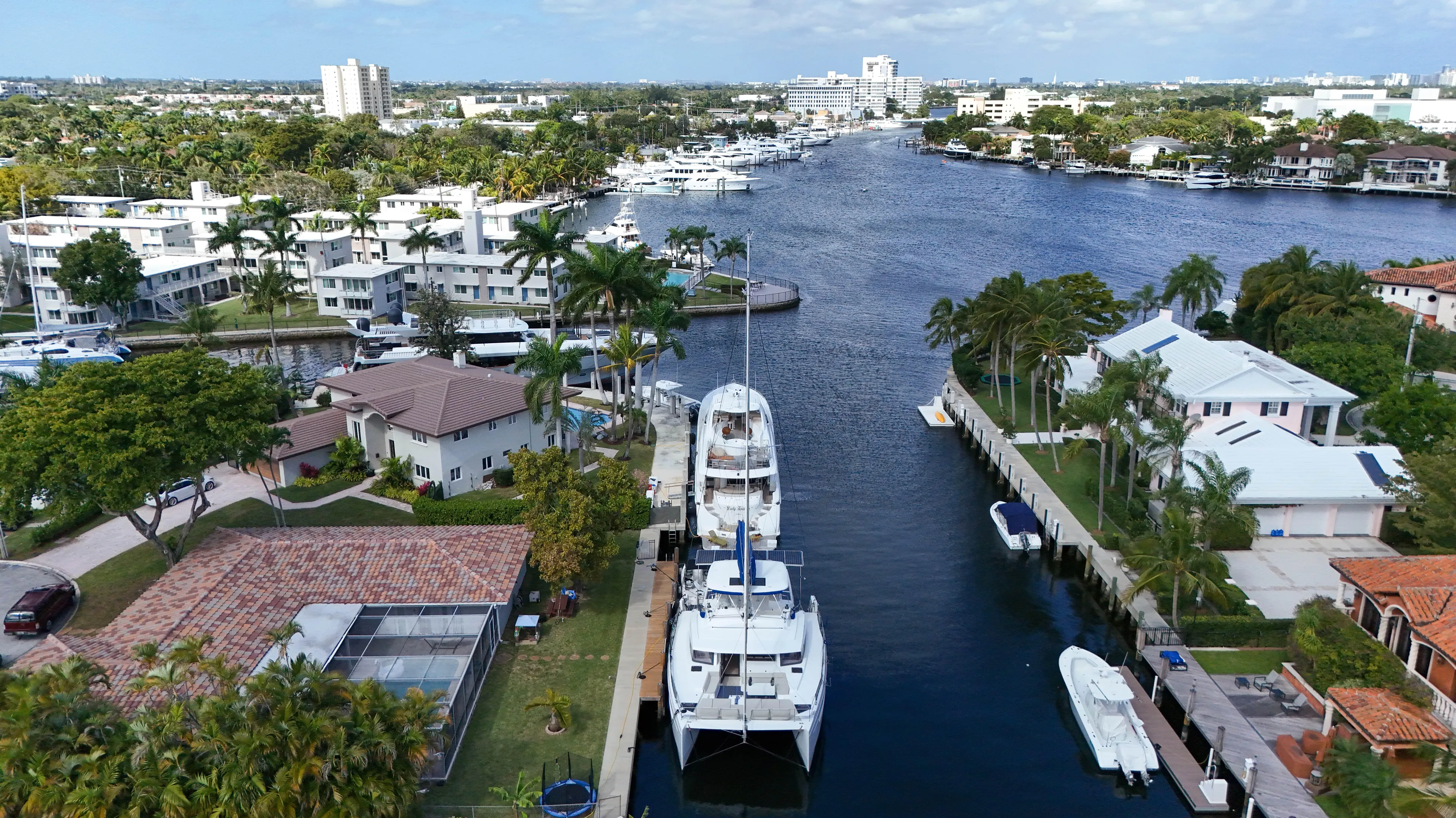 Joy Yacht Photos Pics Aerial view of a Bali 5.4 catamaran docked in a scenic waterfront neighborhood, 2021.
