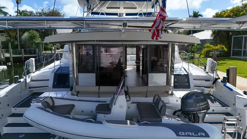 Joy Yacht Photos Pics Luxury Bali 5.4 catamaran yacht with inflatable boat, docked in a sunny marina, 2021 model.