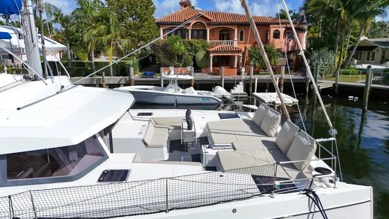 Joy Yacht Photos Pics Luxurious Bali 5.4 catamaran docked near waterfront villa, 2021 model.