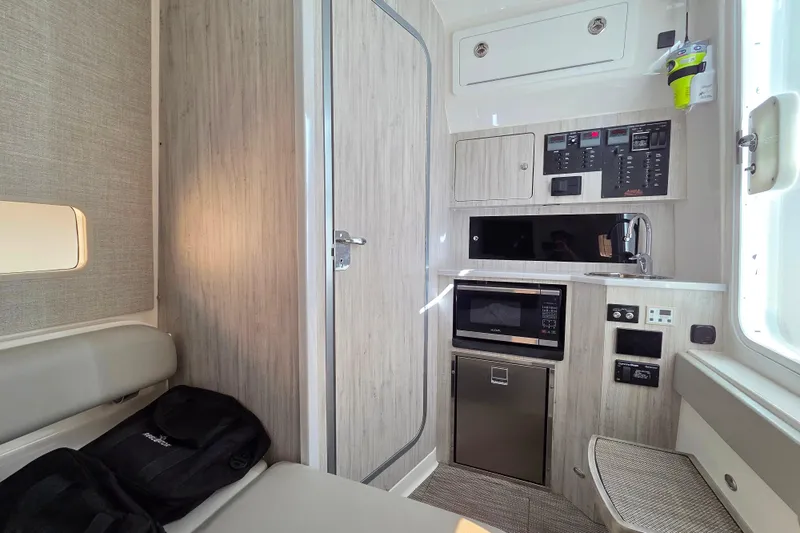  Yacht Photos Pics 2022 Regulator 37 cabin interior with kitchenette, microwave, and control panel.
