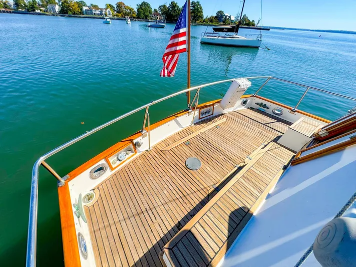 4796tw Yacht Photos Pics 1988 Grand Banks 42 Classic yacht deck with American flag, moored on calm water.