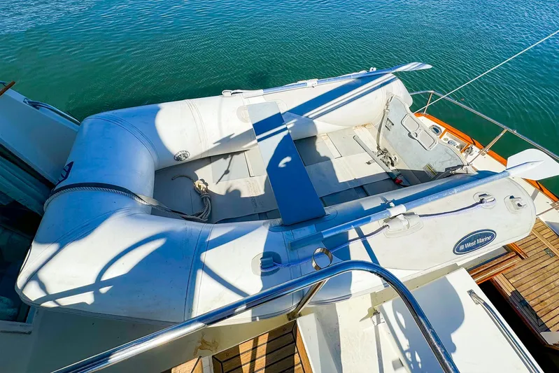 4796tw Yacht Photos Pics Inflatable dinghy on 1988 Grand Banks 42 Classic yacht deck, moored on calm water.