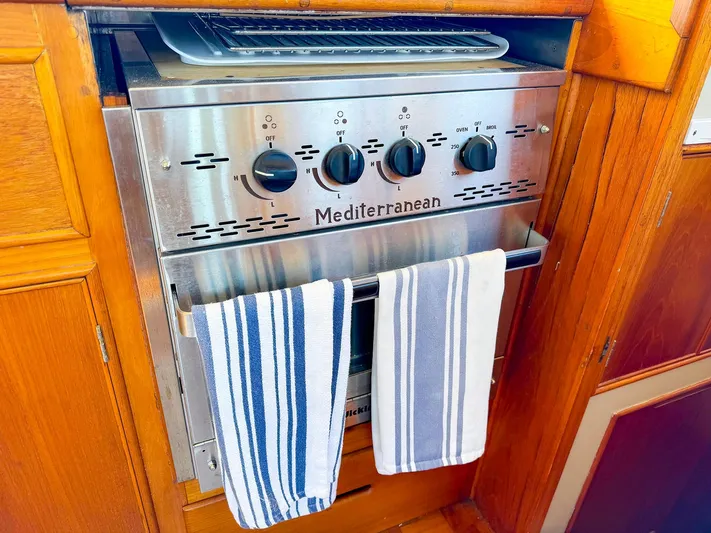 4796tw Yacht Photos Pics Mediterranean stove with striped towels in 1988 Grand Banks 42 Classic yacht kitchen.