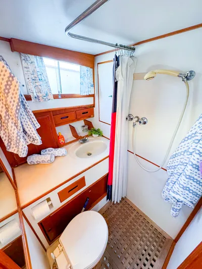 4796tw Yacht Photos Pics 1988 Grand Banks 42 Classic yacht bathroom with shower, sink, and wooden cabinetry.