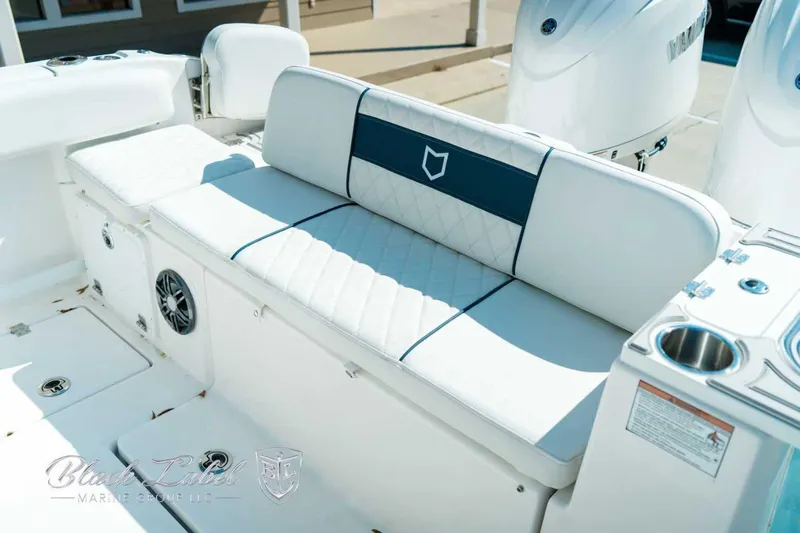 Black Label Marine Yacht Photos Pics 2025 Sea Fox 268 Commander boat interior with white cushioned seating and cup holders.