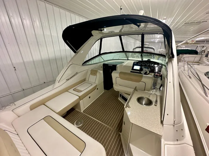  Yacht Photos Pics 2010 Sea Ray 310 Sundancer interior with seating, helm, and kitchenette in a storage facility.