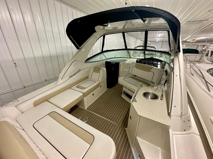  Yacht Photos Pics 2010 Sea Ray 310 Sundancer interior with seating, sink, and helm in a covered storage area.