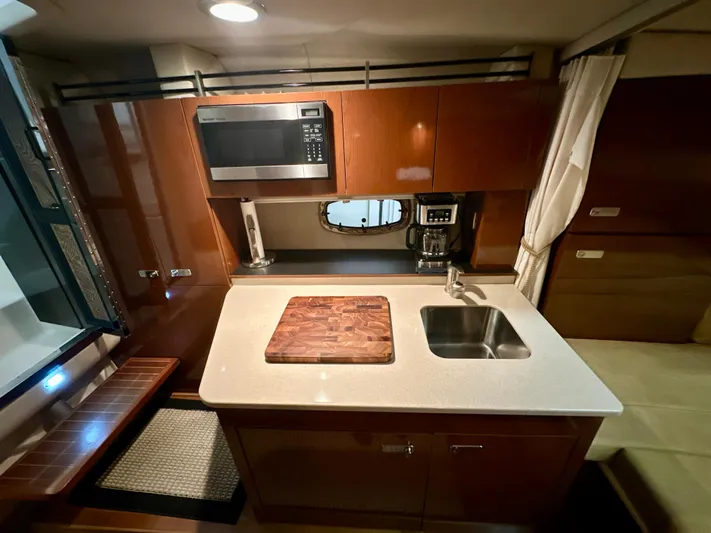  Yacht Photos Pics Interior of 2010 Sea Ray 310 Sundancer yacht kitchen with sink, microwave, and cutting board.