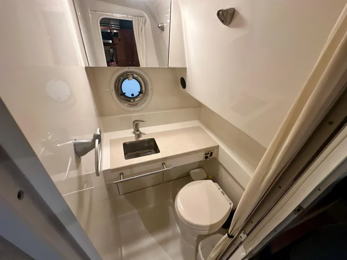  Yacht Photos Pics 2010 Sea Ray 310 Sundancer bathroom with sink, toilet, and porthole window.