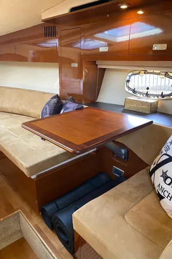  Yacht Photos Pics Luxurious interior of 2010 Sea Ray 310 Sundancer with wooden table and beige seating.