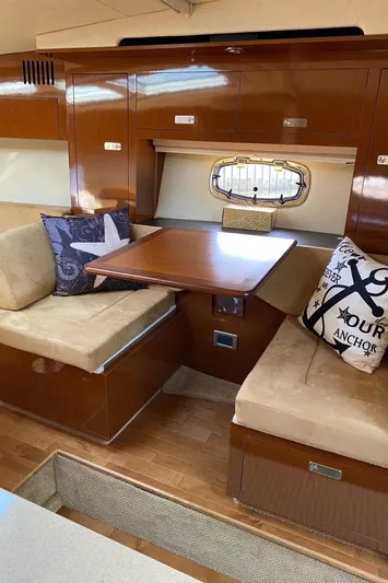  Yacht Photos Pics Interior of 2010 Sea Ray 310 Sundancer with cozy seating and wooden table.