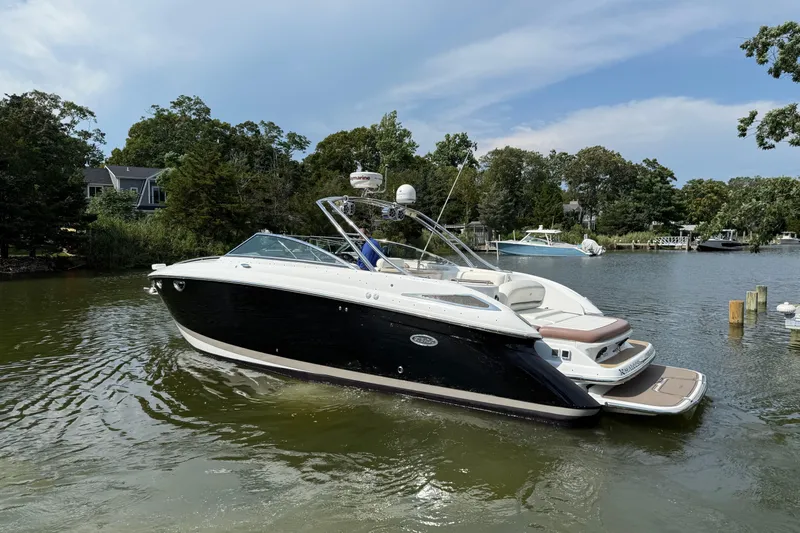  Yacht Photos Pics 2013 Cobalt 323 boat on a serene lake with lush greenery.