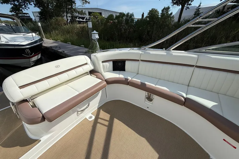  Yacht Photos Pics 2013 Cobalt 323 boat interior with white and brown seating, docked near greenery.