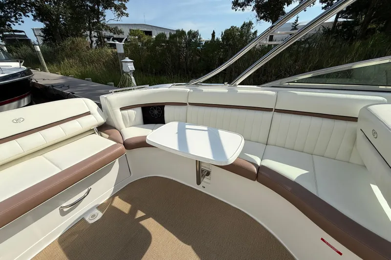  Yacht Photos Pics 2013 Cobalt 323 boat interior with white and brown seating, small table, and outdoor setting.