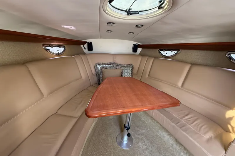  Yacht Photos Pics Luxurious interior of a 2013 Cobalt 323 boat with beige seating and wooden table.