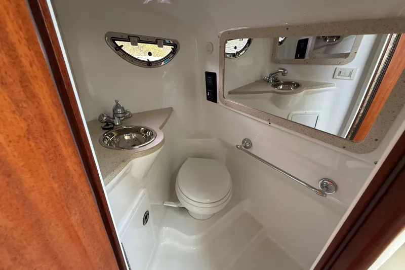  Yacht Photos Pics Compact bathroom in 2013 Cobalt 323 boat with sink, toilet, and mirror.