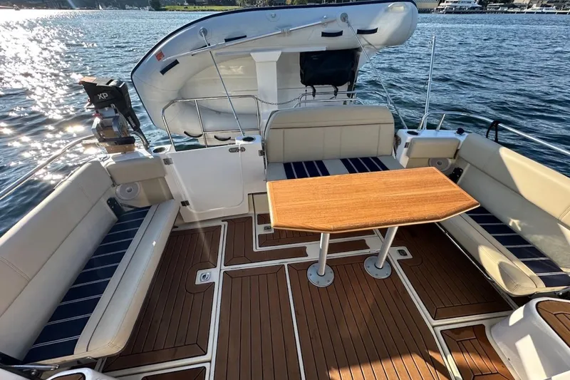 Buoy Boys Yacht Photos Pics 2025 Ranger Tugs R-29 CB boat interior with seating and wooden table on water.