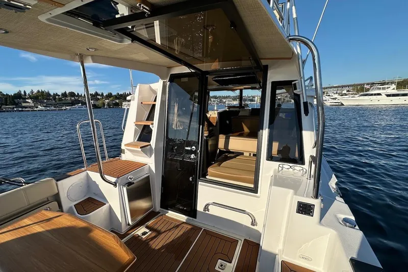 Buoy Boys Yacht Photos Pics 2025 Ranger Tugs R-29 CB boat interior with wood accents and seating, docked on a sunny day.